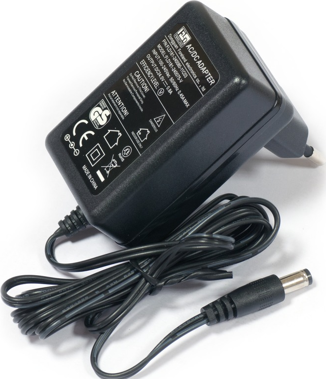 Adaptateur AC/DC noir avec cordon d'alimentation. Il comporte des étiquettes et des symboles. La prise est en haut à droite. Le cordon a un connecteur.