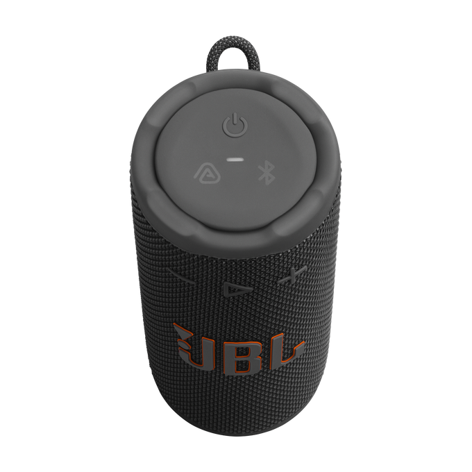 Un altavoz JBL negro y gris con el logotipo naranja de JBL. La parte superior tiene botones de encendido, bluetooth y otras funciones. Tiene un asa de transporte.