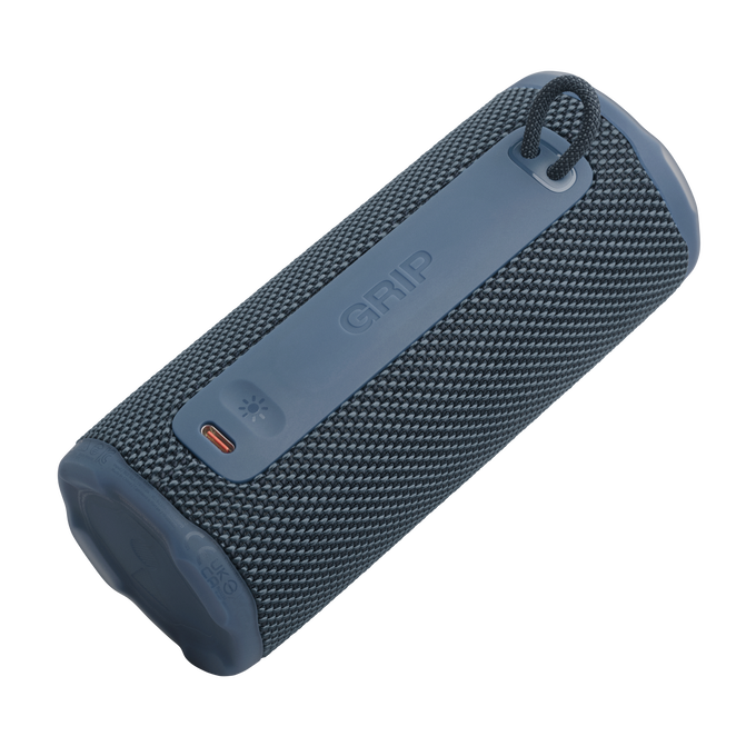 Un altavoz cilíndrico azul y gris con la palabra 'GRIP'. Tiene un asa y un botón de encendido.