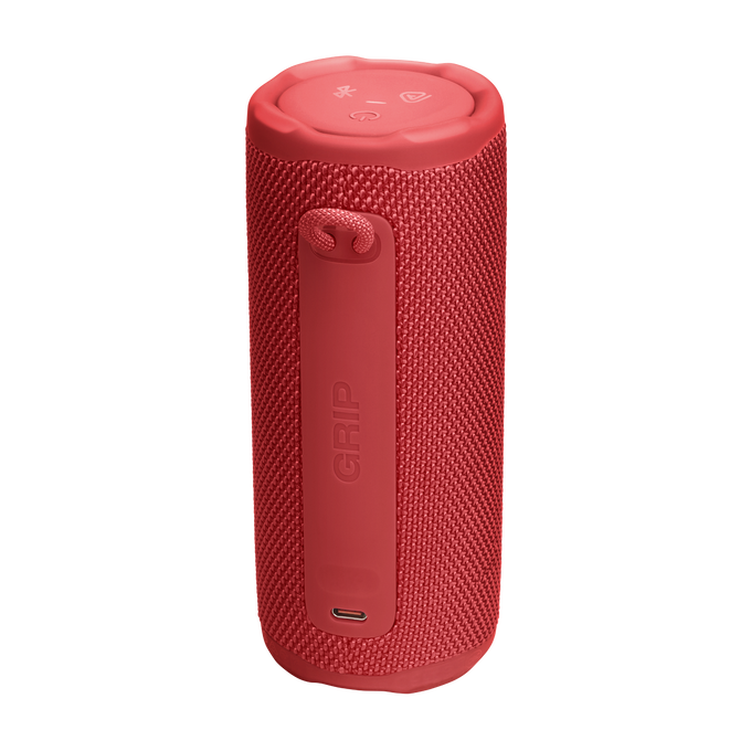 Altavoz cilíndrico rojo con asa y la palabra 'GRIP'. Tiene botones arriba y un puerto de carga.