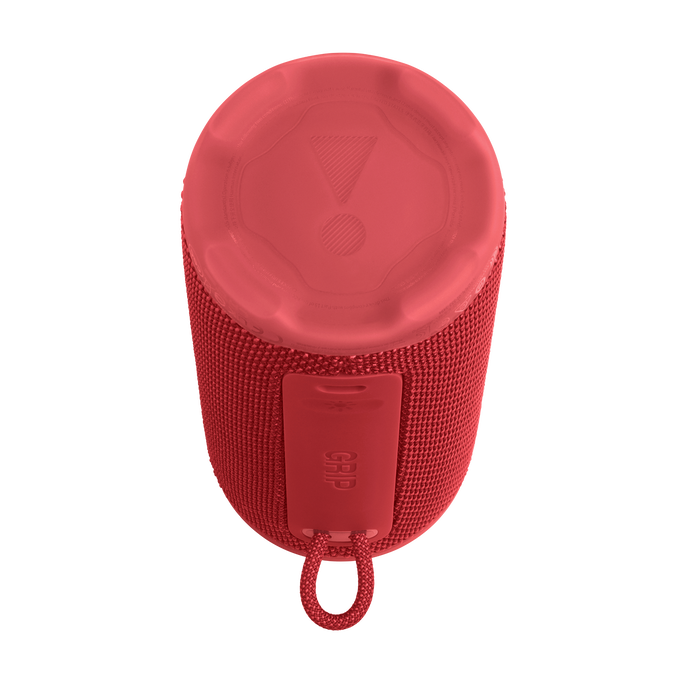 Altavoz cilíndrico rojo con cuerpo de tela texturizada. La parte superior tiene el logo de JBL y una correa inferior.