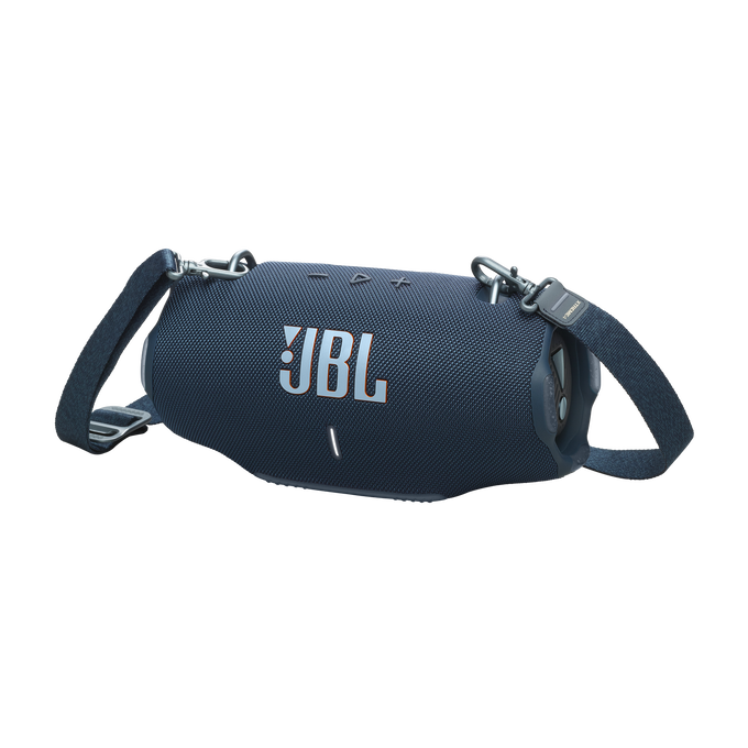 Un altavoz JBL azul con correa para el hombro. El logotipo de JBL es visible. El fondo es negro.
