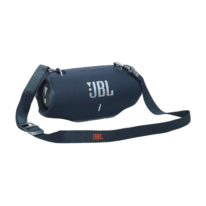 Un altavoz JBL azul oscuro con una correa de transporte. El logo de JBL es visible. El altavoz está sobre un fondo oscuro con detalles rojos.