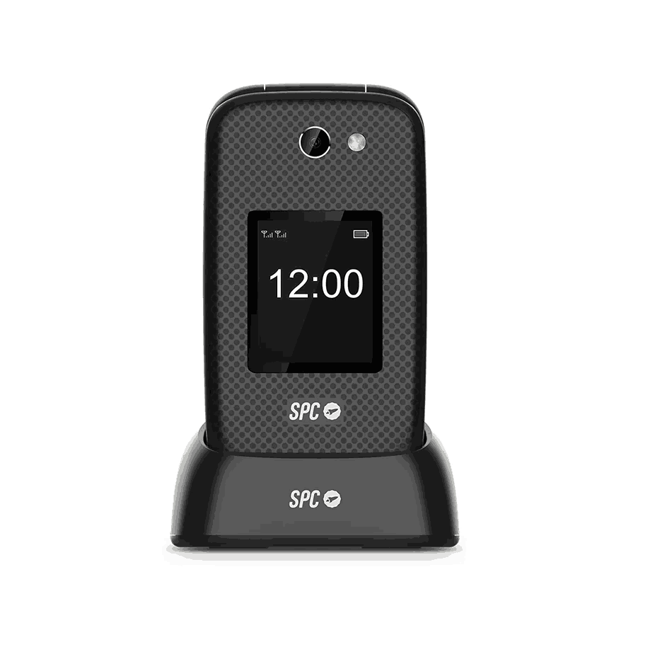 Un teléfono plegable negro que muestra las 12:00, en su base de carga. El teléfono tiene una cámara y la marca SPC es visible.