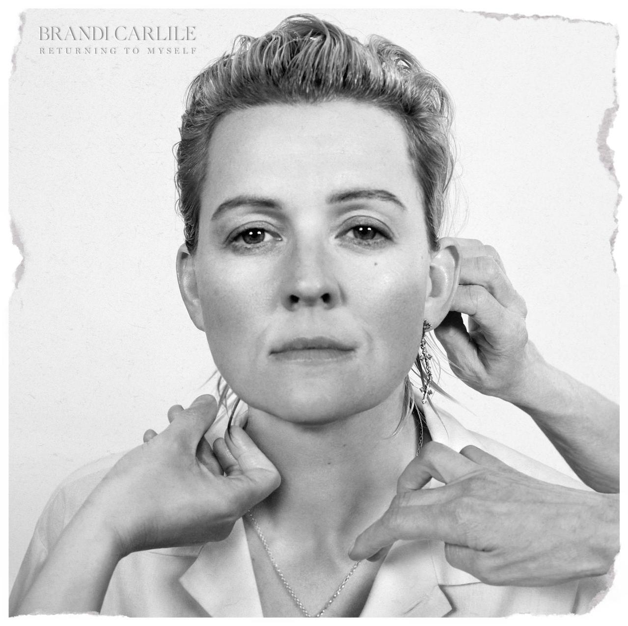 Fekete-fehér portré Brandi Carlile-ról, kezek igazítják a fülét és a nyakláncát. Szöveg: Brandi Carlile, Returning to Myself.
