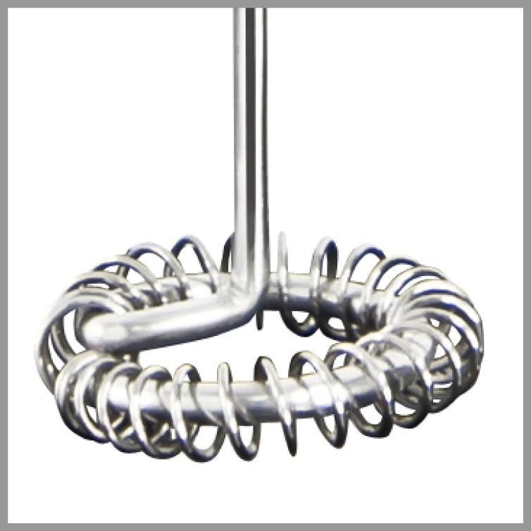 Zbliżenie spieniacza do mleka ze stali nierdzewnej. Ma pętlę na dole i długi uchwyt.