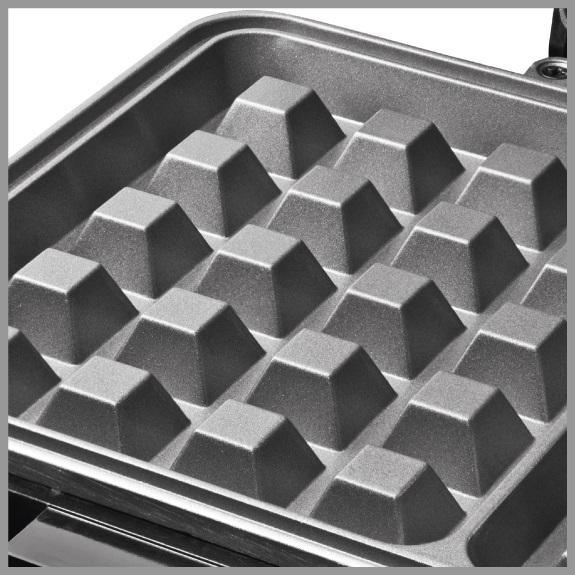 Zbliżenie szarego wnętrza gofrownicy z formami w kształcie piramid. Powierzchnia jest nieprzywierająca i przeznaczona do równomiernego pieczenia.