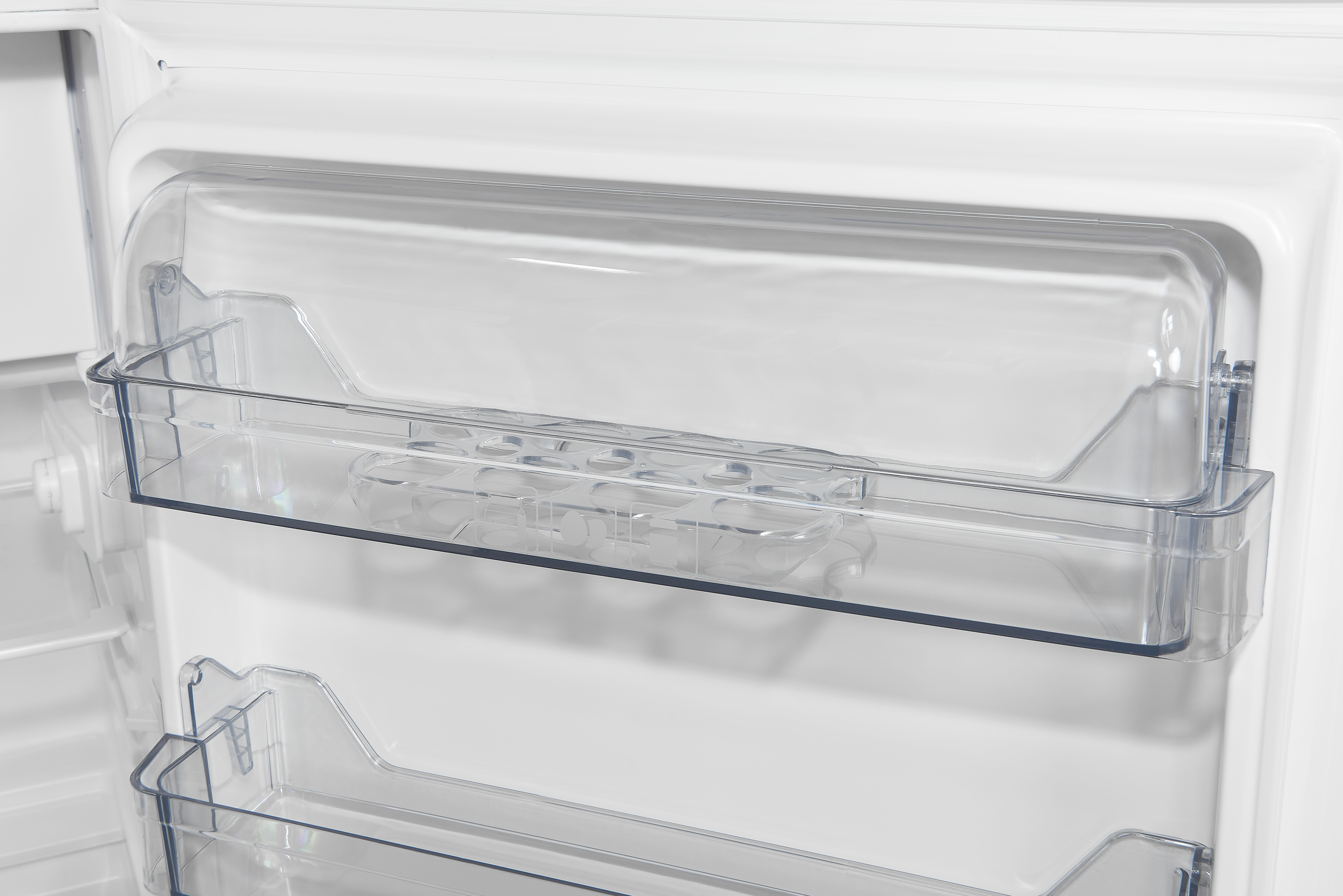 Im Inneren eines weißen Kühlschranks befinden sich transparente Kunststoffregale. Ein Regal enthält einen Eierbehälter. Die Tür ist sichtbar.