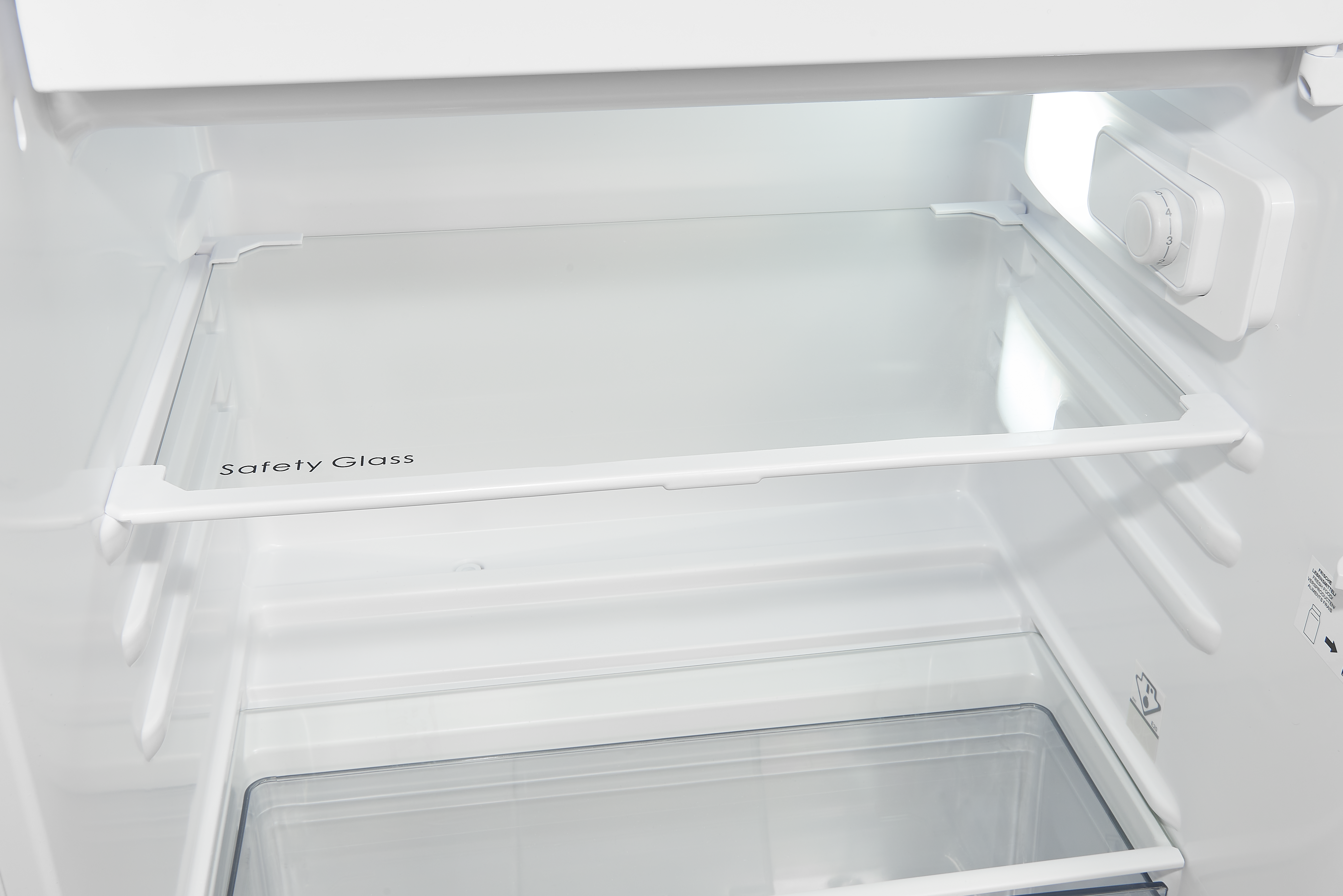 Im Inneren eines weißen Kühlschranks: Glasböden, ein Bedienfeld mit Zahlen und die Aufschrift 'Safety Glass' sind sichtbar.