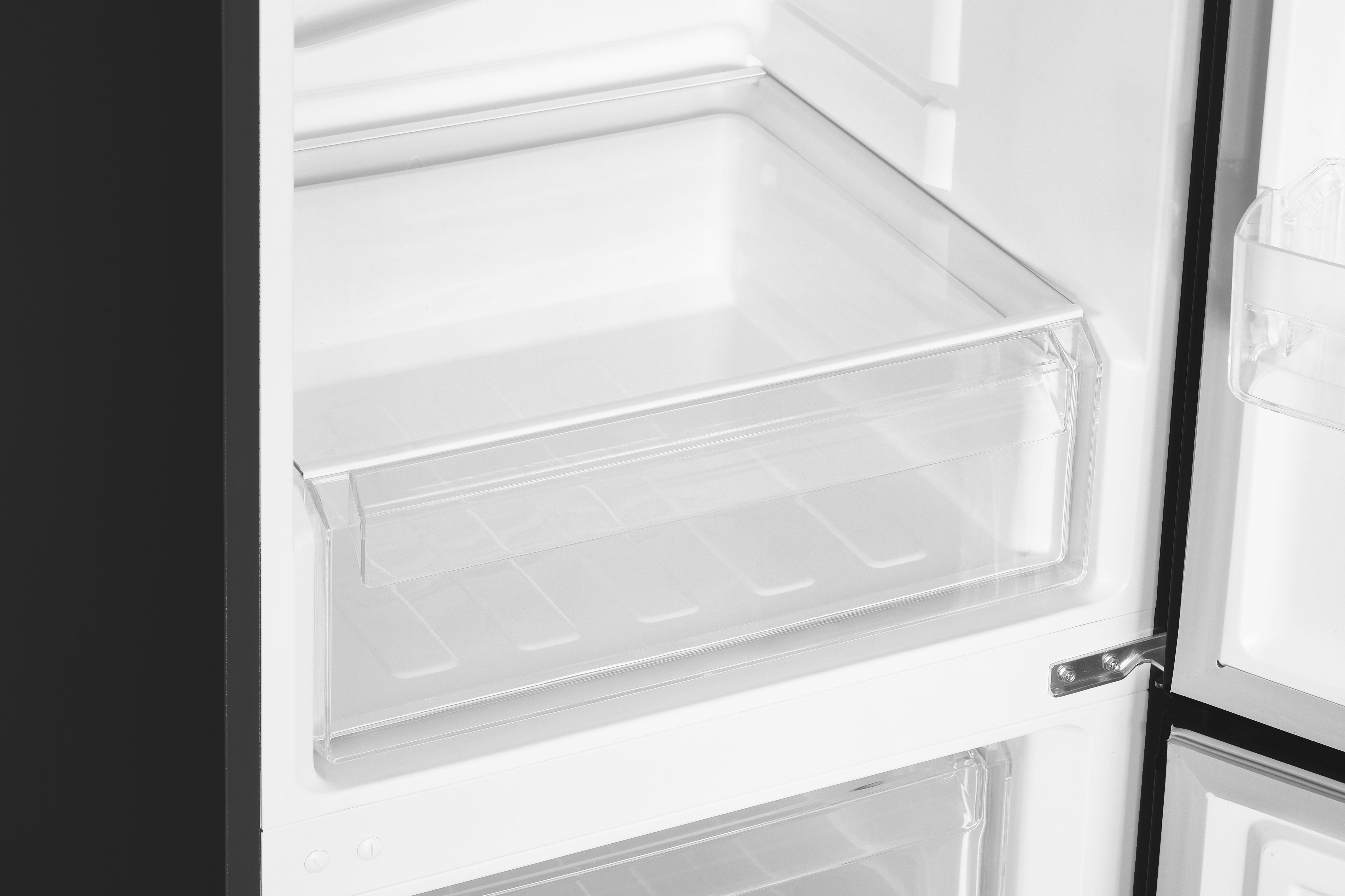 Im Kühlschrank ist eine transparente Schublade zu sehen. Die Tür ist geöffnet und zeigt das weiße und schwarze Innere.