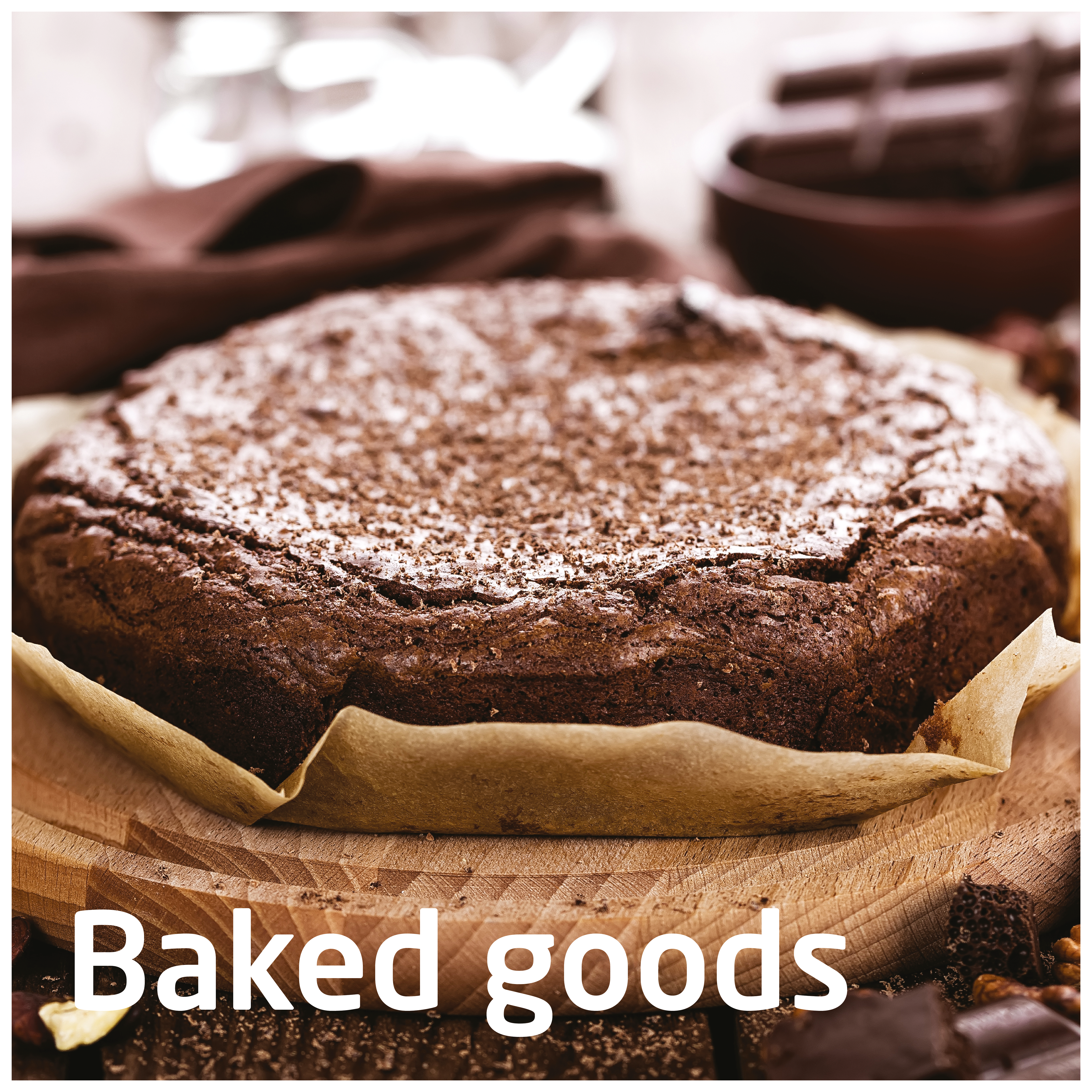 Okrągłe ciasto posypane cukrem pudrem na papierze do pieczenia, umieszczone na drewnianej desce. Rozmyte tło.