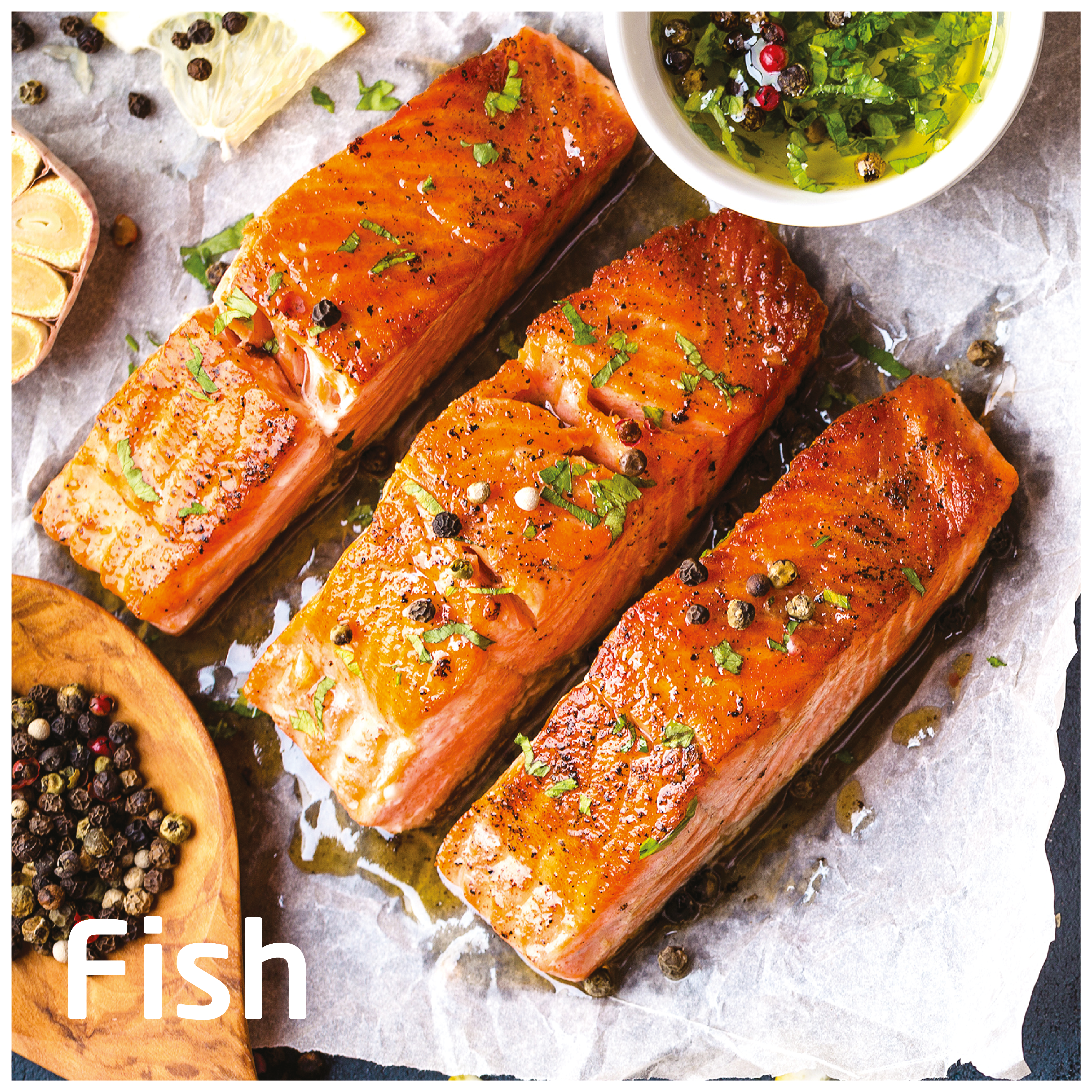 Gotowane filety z łososia z pieprzem i ziołami na papierze, plasterki cytryny, czosnek i miska sosu.