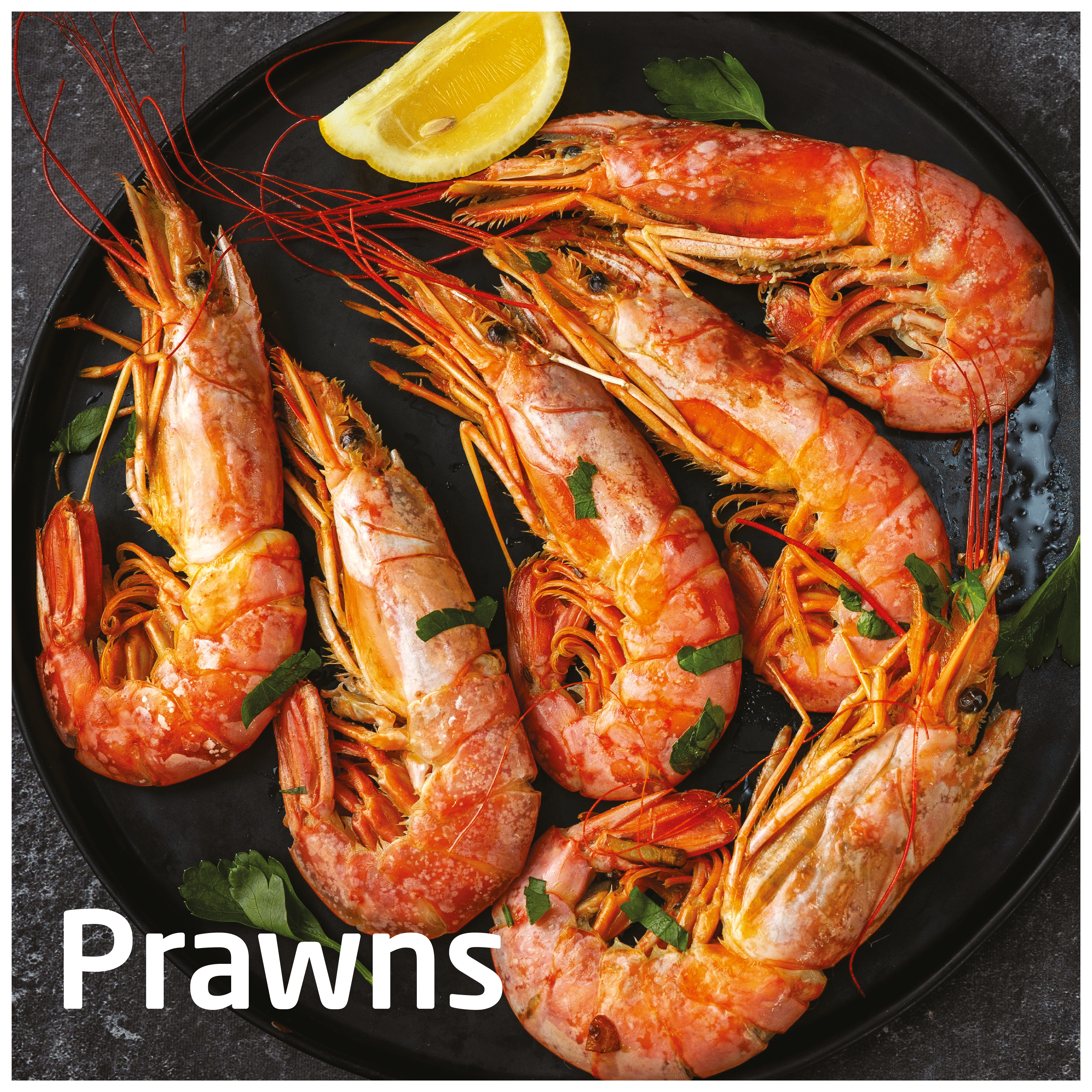 Gotowane krewetki na czarnym talerzu z plasterkiem cytryny. Krewetki są pomarańczowe.