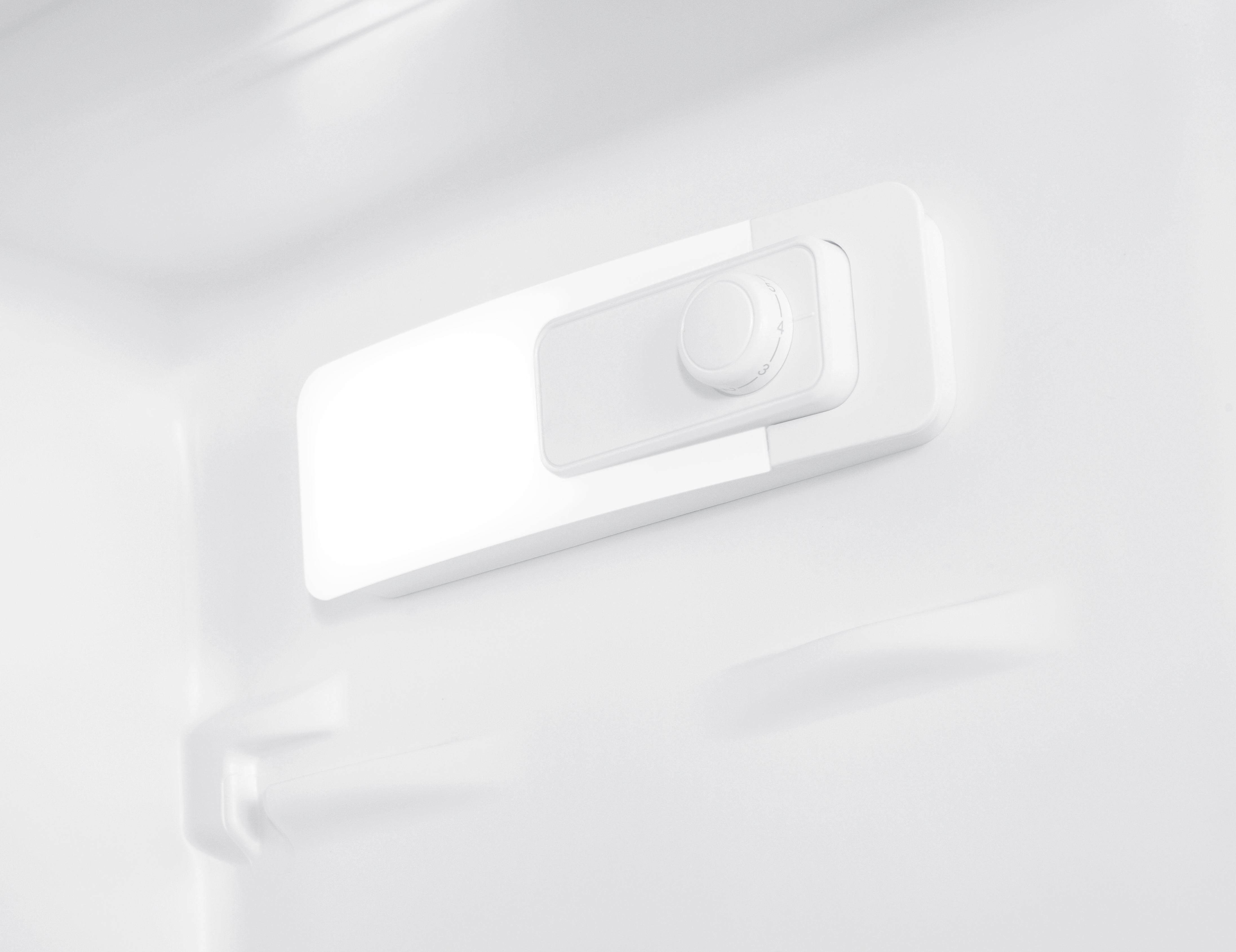 Dentro de un refrigerador blanco, se ve un panel de control blanco con una perilla. Los números 1-5 están en la perilla.