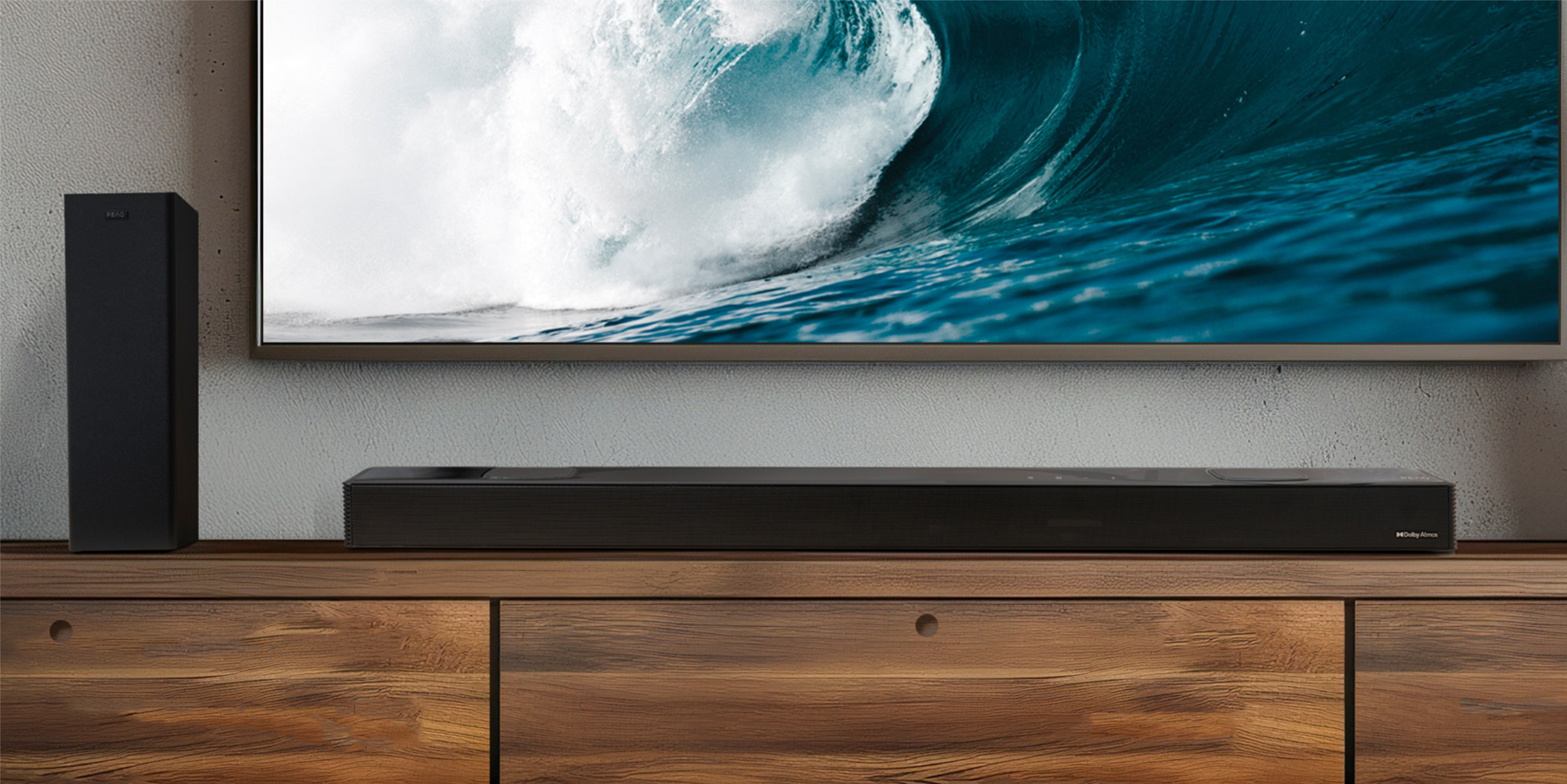 Eine schwarze Soundbar und ein Lautsprecher auf einem Holzschrank, mit einem Fernseher, der eine Welle zeigt. Die Szene ist drinnen.