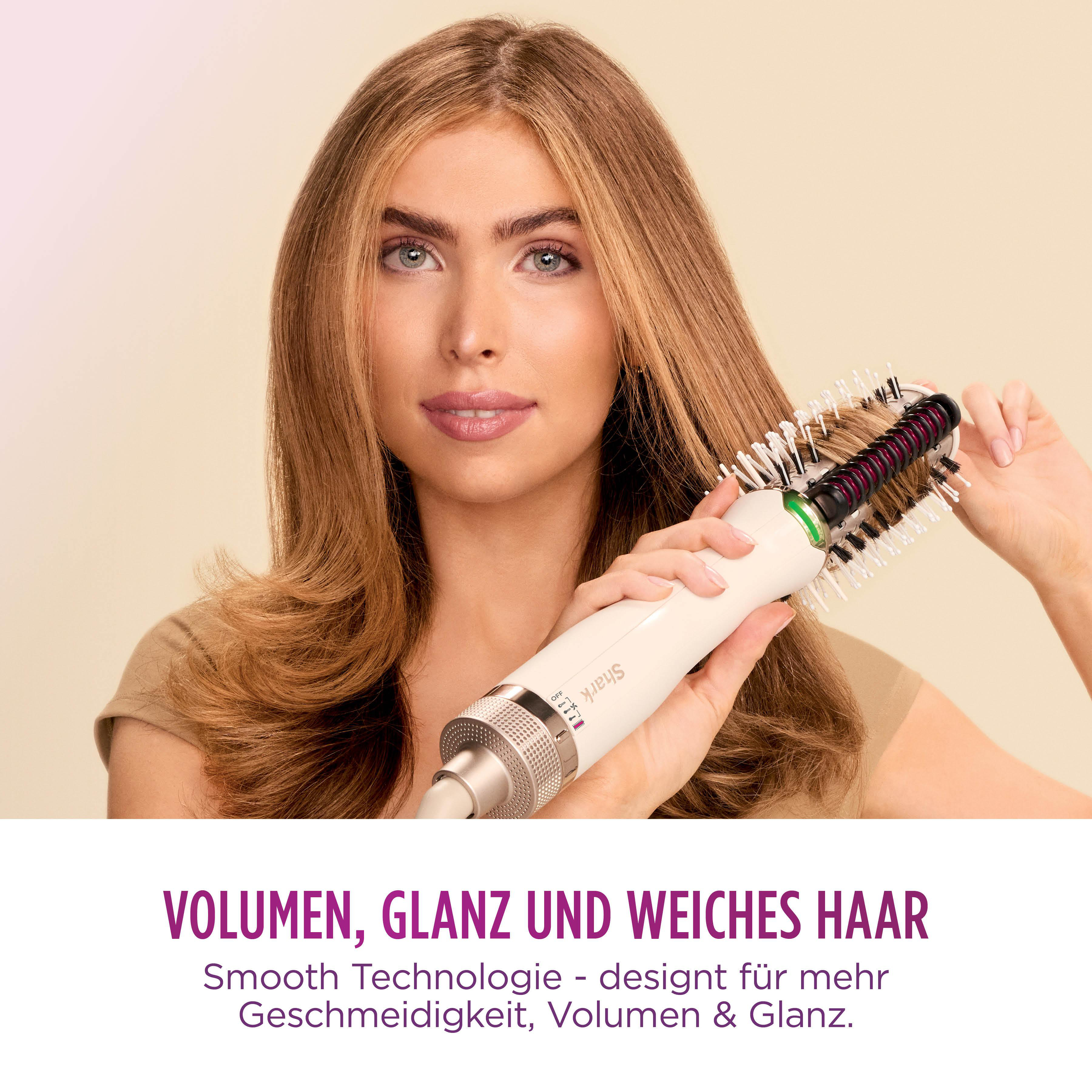Eine Frau verwendet ein weiß-schwarzes Haarstyling-Werkzeug auf ihrem langen, hellbraunen Haar. Der Hintergrund ist beige.