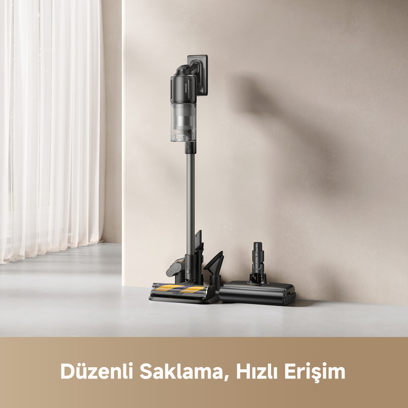 Beyaz bir yüzey üzerinde, bej bir duvar ve beyaz bir perde önünde duran, siyah kablosuz bir elektrikli süpürge.