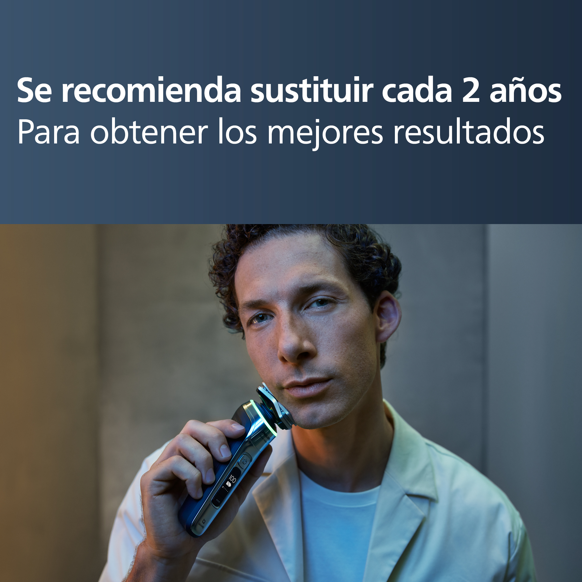 Un hombre se afeita con una afeitadora eléctrica. El texto superior dice: 'Reemplace cada 2 años para obtener los mejores resultados'.