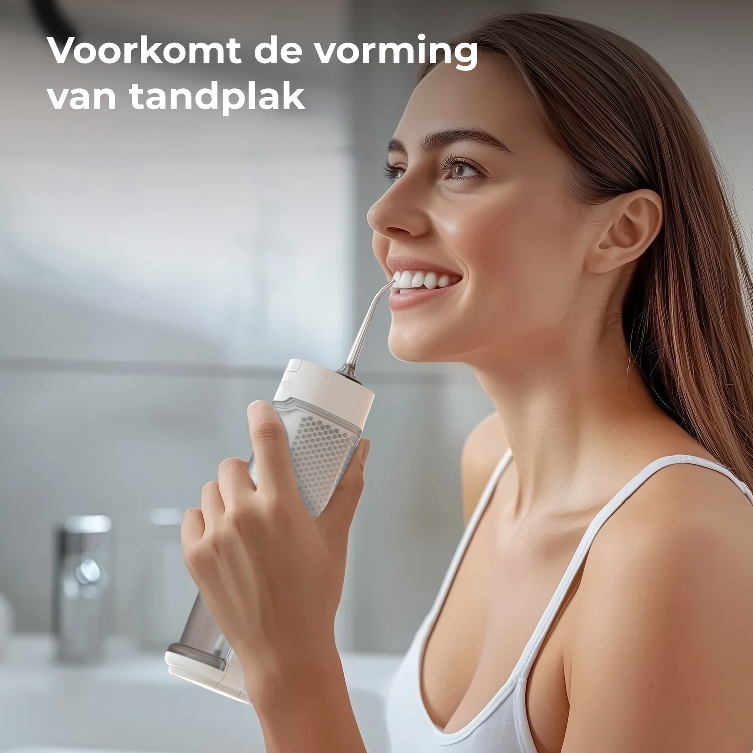 Woman using a water flosser, smiling. She is in a bathroom, holding the device. Background includes a sink and a mirror.