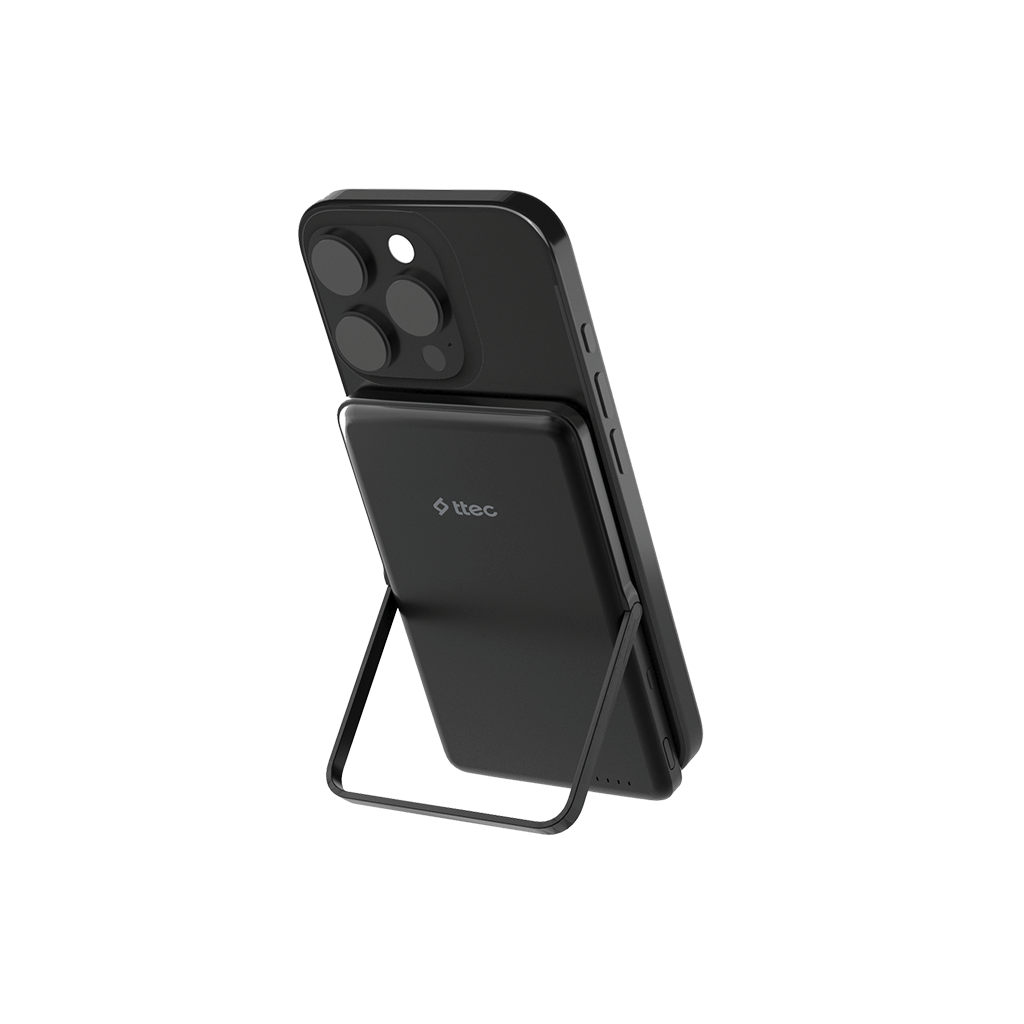 Siyah bir akıllı telefon, siyah bir powerbank'e bağlı ve bir stand ile destekleniyor. Powerbank üzerinde 'ttec' logosu var.