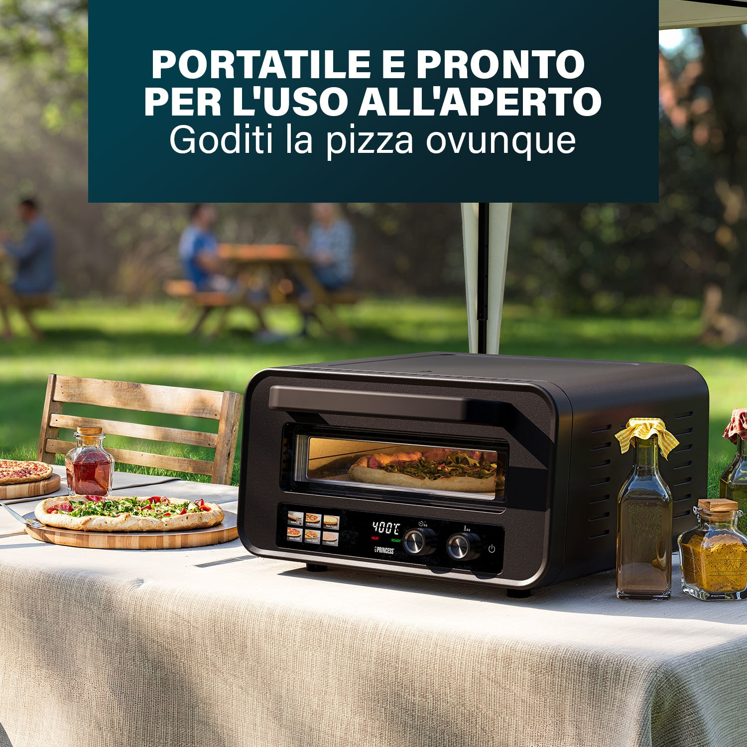 Un forno per pizza nero su un tavolo, pizza su un tagliere di legno, bottiglie di vetro e persone sullo sfondo, testo: portatile e pronto.