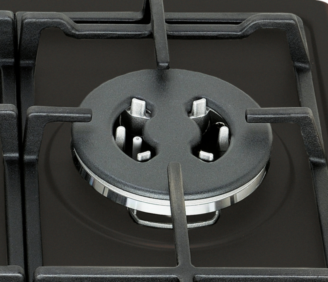 Zbliżenie czarnego palnika kuchenki gazowej. Widoczny jest czarny ruszt i nasadka palnika ze srebrnymi akcentami.