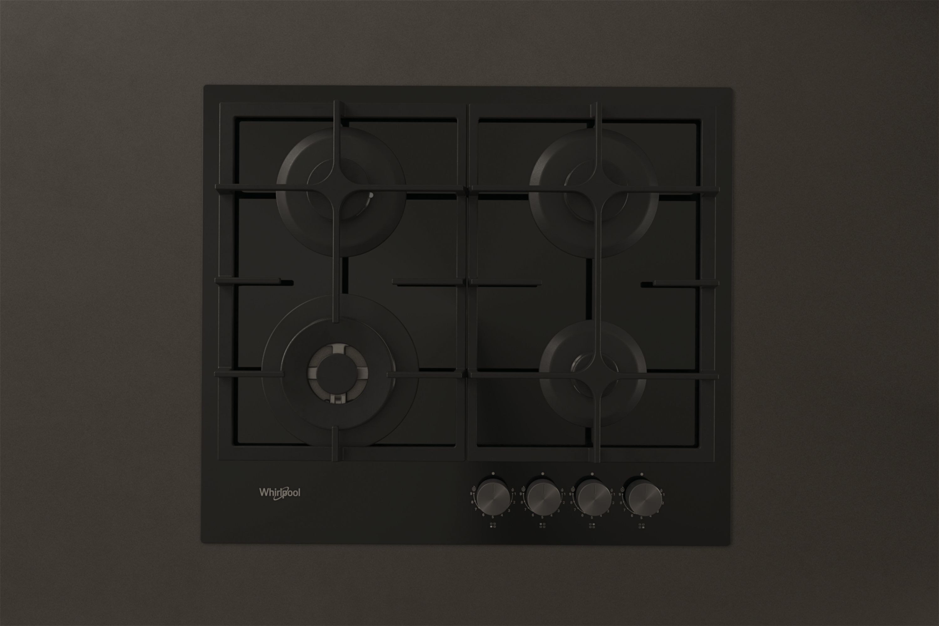 Czarna płyta gazowa Whirlpool z czterema palnikami i pokrętłami na ciemnym tle.