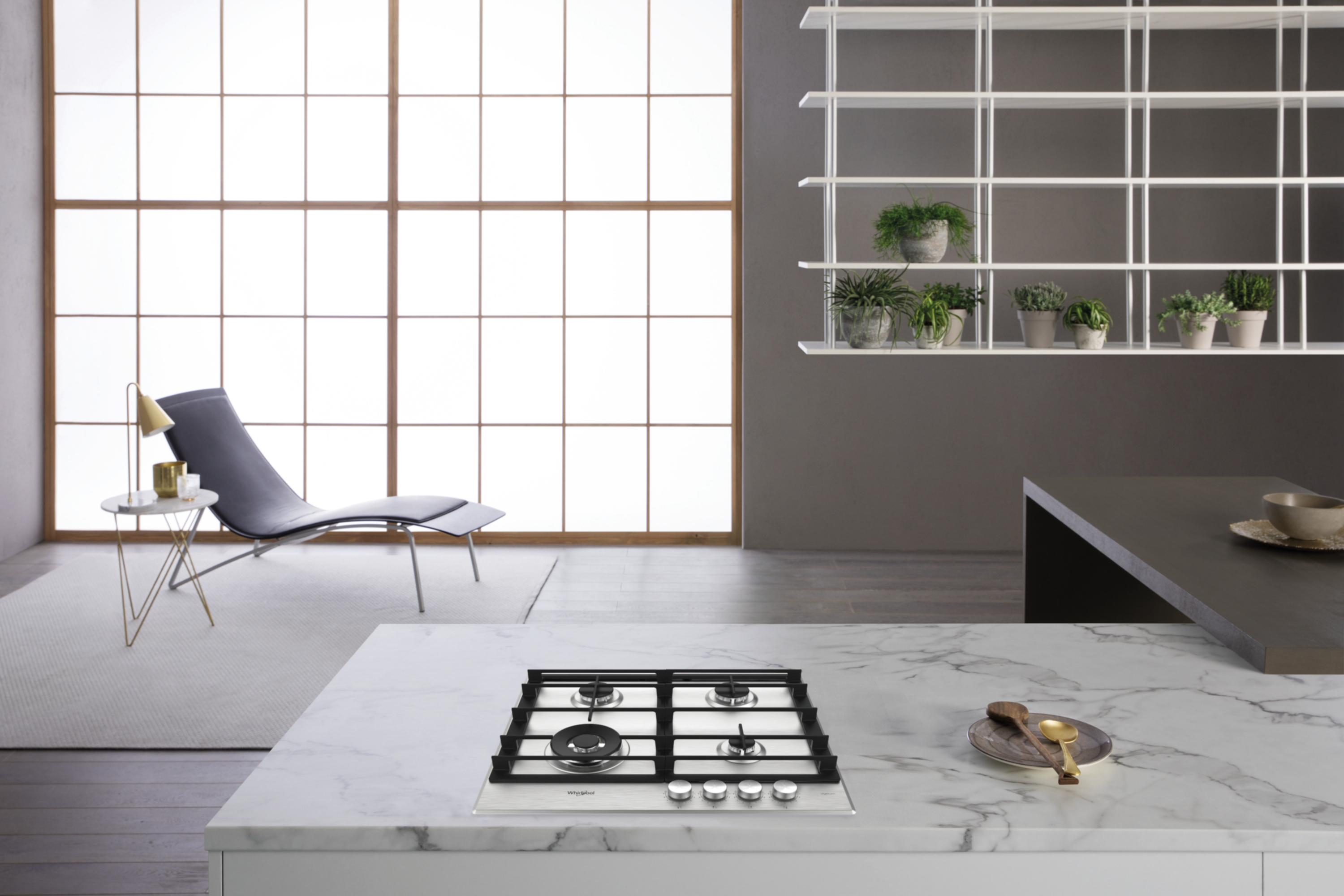 Kuchnia z marmurowym blatem, kuchenką gazową, roślinami i krzesłem w pobliżu dużego okna.