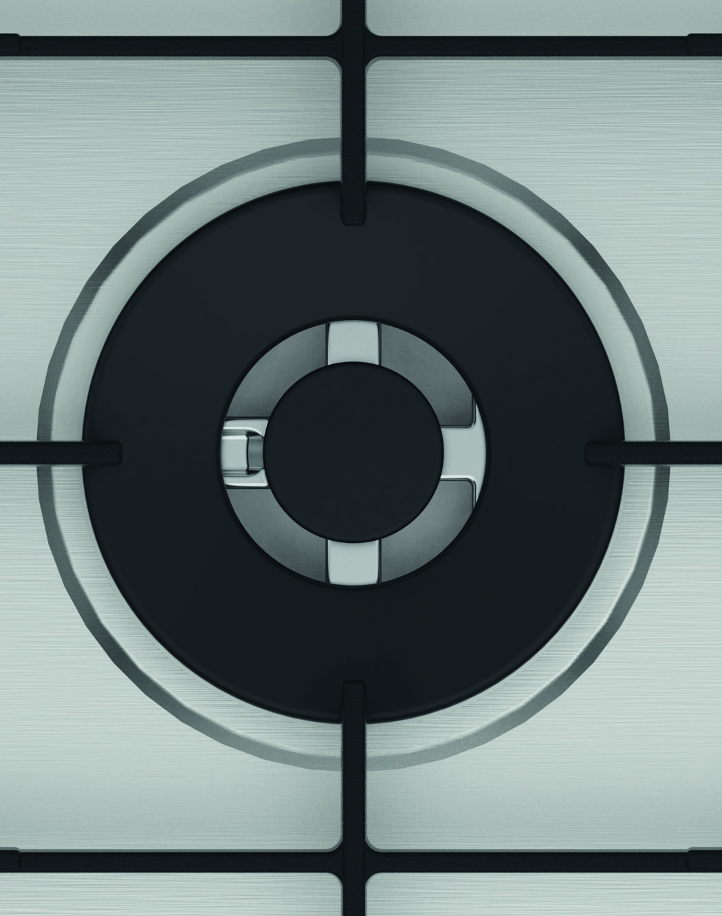 Zbliżenie palnika kuchenki. Czarny pierścień palnika ze srebrnym pierścieniem wewnętrznym. Powierzchnia ze stali nierdzewnej z czarnymi wspornikami w kształcie krzyża.