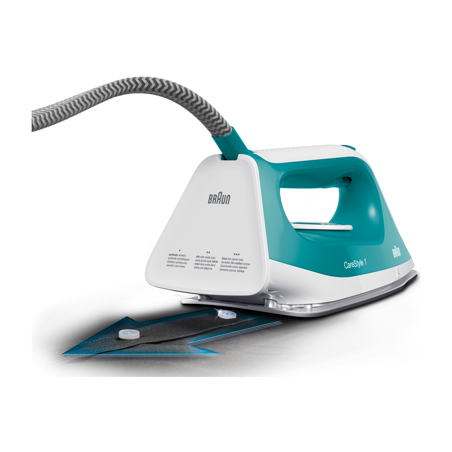 Un ferro da stiro Braun CareStyle 1 turchese e bianco con un cavo grigio. Si trova su una superficie bianca con un tessuto blu e nero sotto.