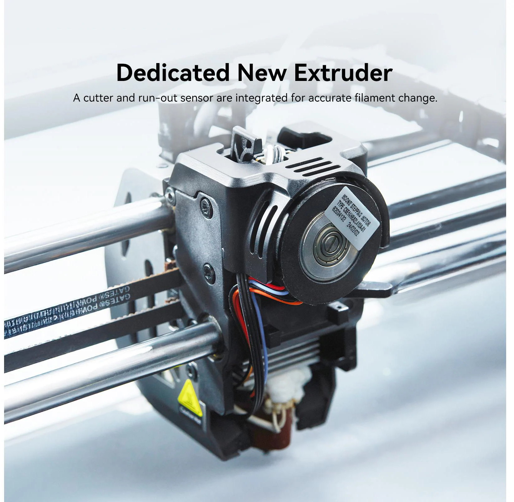Gros plan d'une extrudeuse d'imprimante 3D avec étiquettes, fils et courroie. Le texte Dedicated New Extruder est en haut.