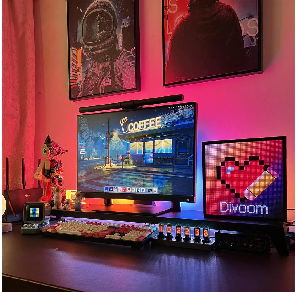 Ein Schreibtisch-Setup mit Monitor, Tastatur und Pixelkunst-Anzeige. Poster und Umgebungsbeleuchtung schaffen eine farbenfrohe Umgebung.