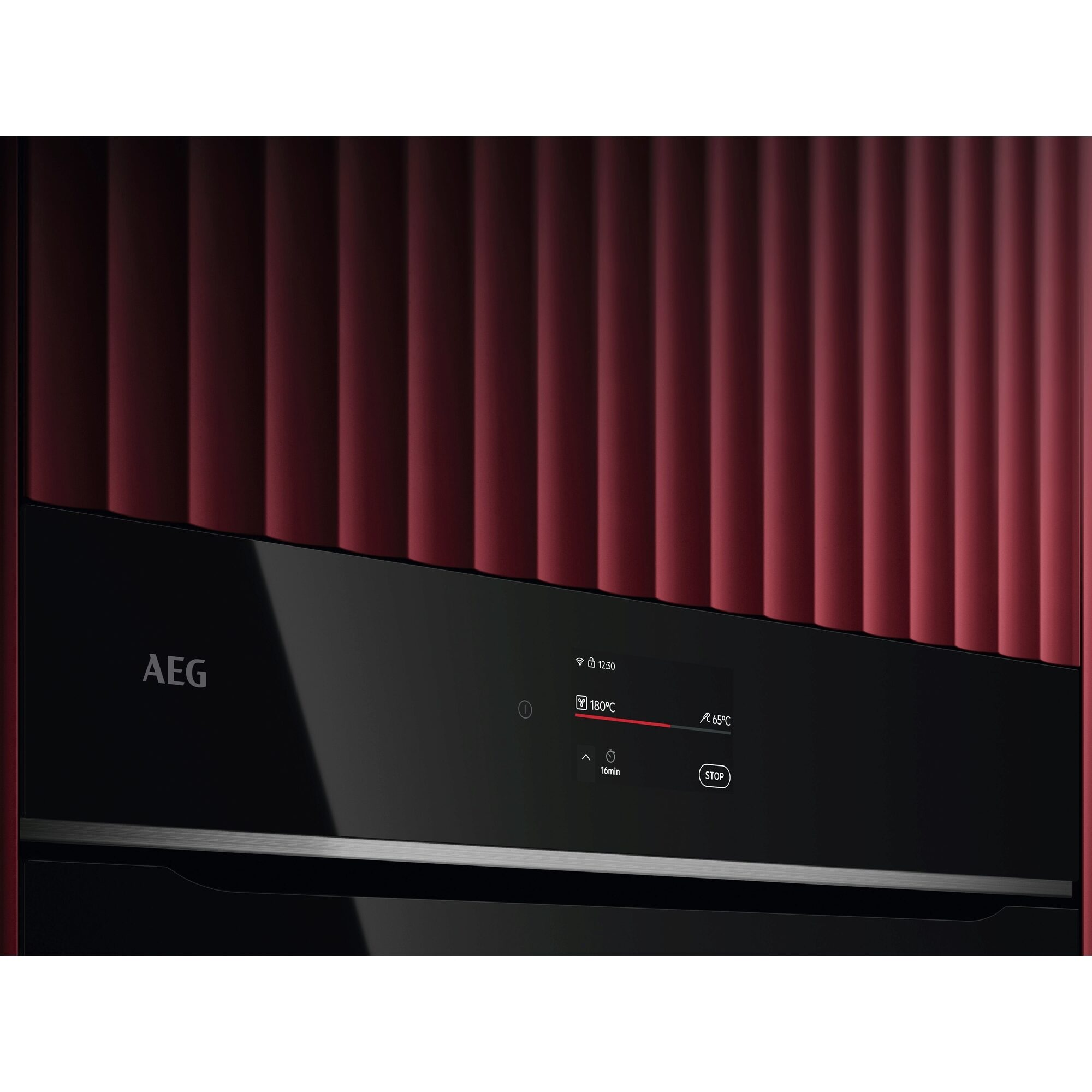 Un horno AEG con panel frontal negro, panel lateral rojo y pantalla digital con ajustes. El fondo es un panel rojo.