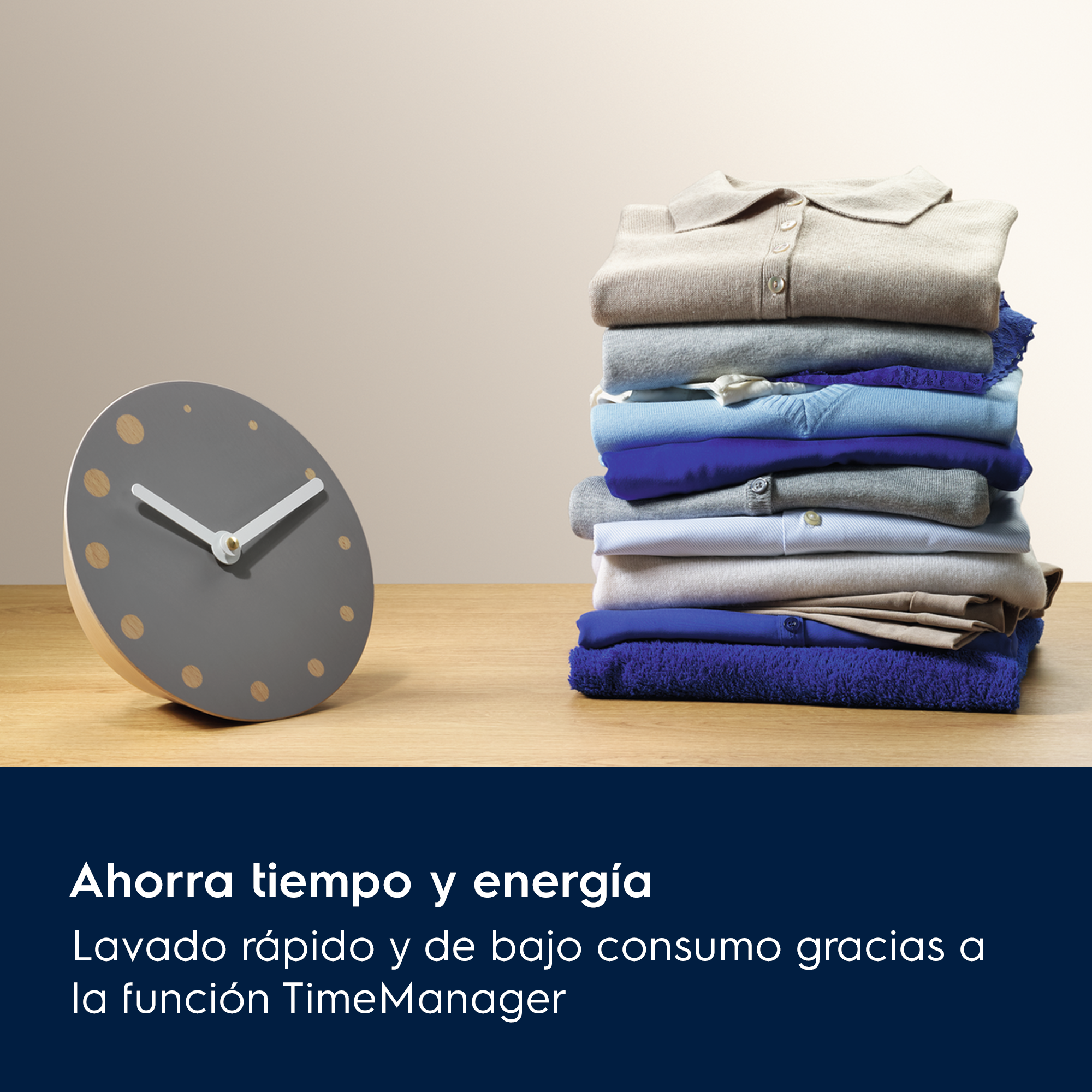 Un reloj y ropa doblada sobre una superficie de madera. La ropa es de diferentes colores.