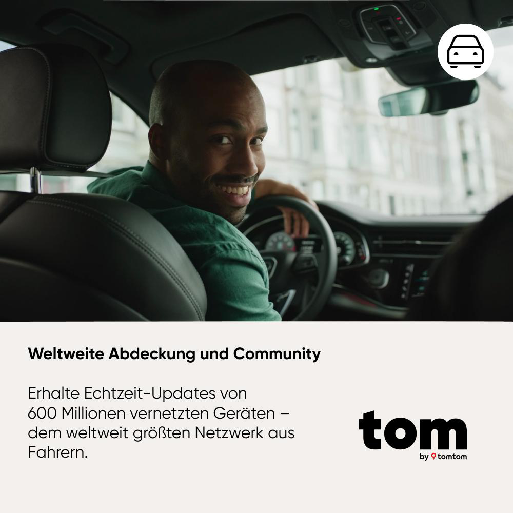 Ein lächelnder schwarzer Mann im Auto blickt zurück. Er hält das Lenkrad. Text und Logo unten.
