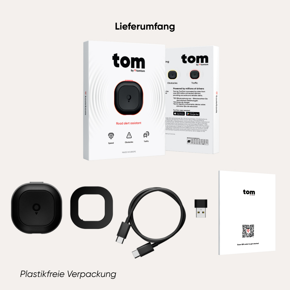 Produktbox mit Gerät, Kabel und Handbuch. Text auf der Box: tom, Road alert assistant. Unten: Plastikfreie Verpackung.
