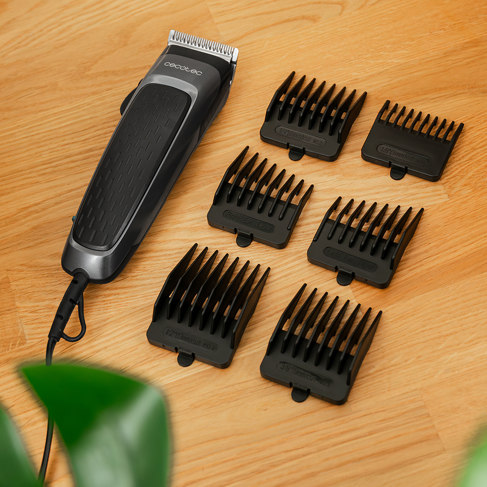 Una cortadora de cabello negra y gris con múltiples protectores negros sobre una superficie de madera.