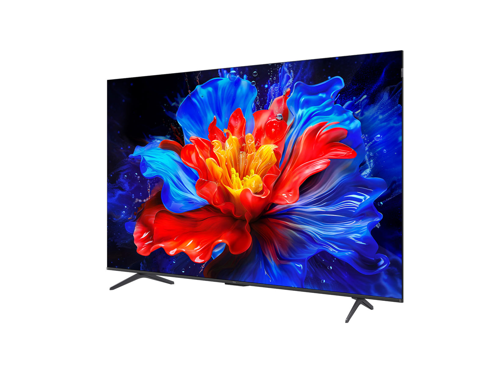 Una pantalla de TV muestra una vibrante imagen floral con pétalos rojos, azules y amarillos sobre un fondo oscuro, en una superficie blanca.