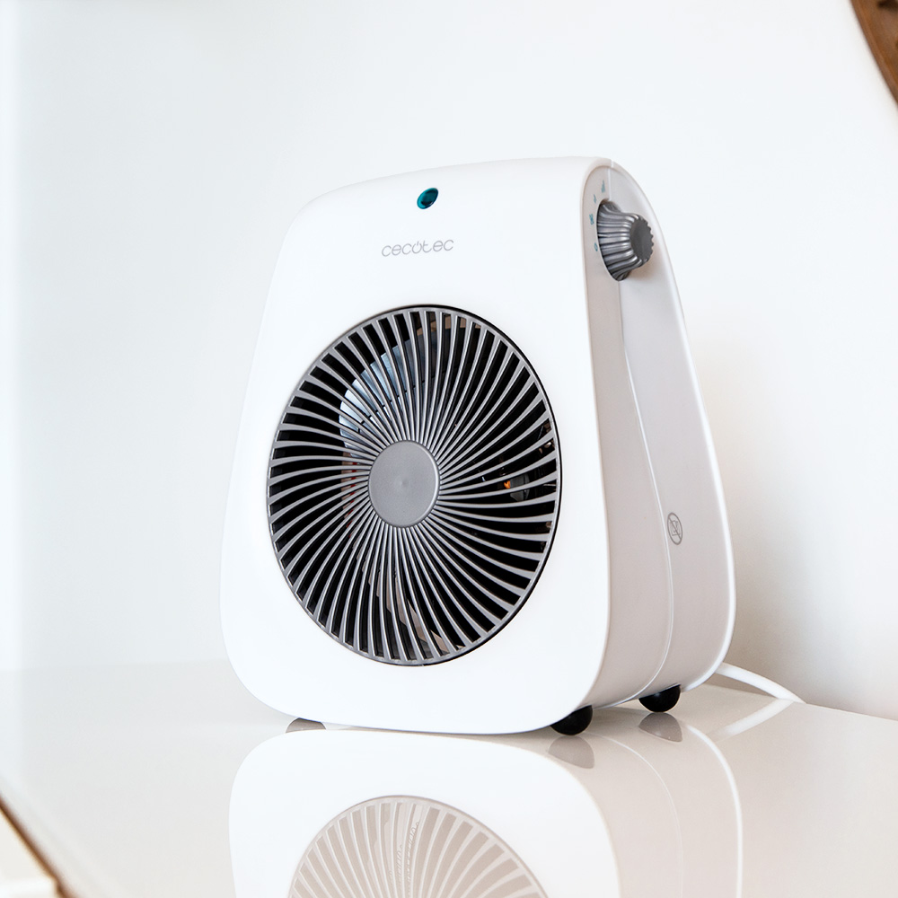 Un calefactor Cecotec blanco sobre una superficie blanca y brillante. Tiene un ventilador redondo, una perilla de control y un indicador de encendido azul.