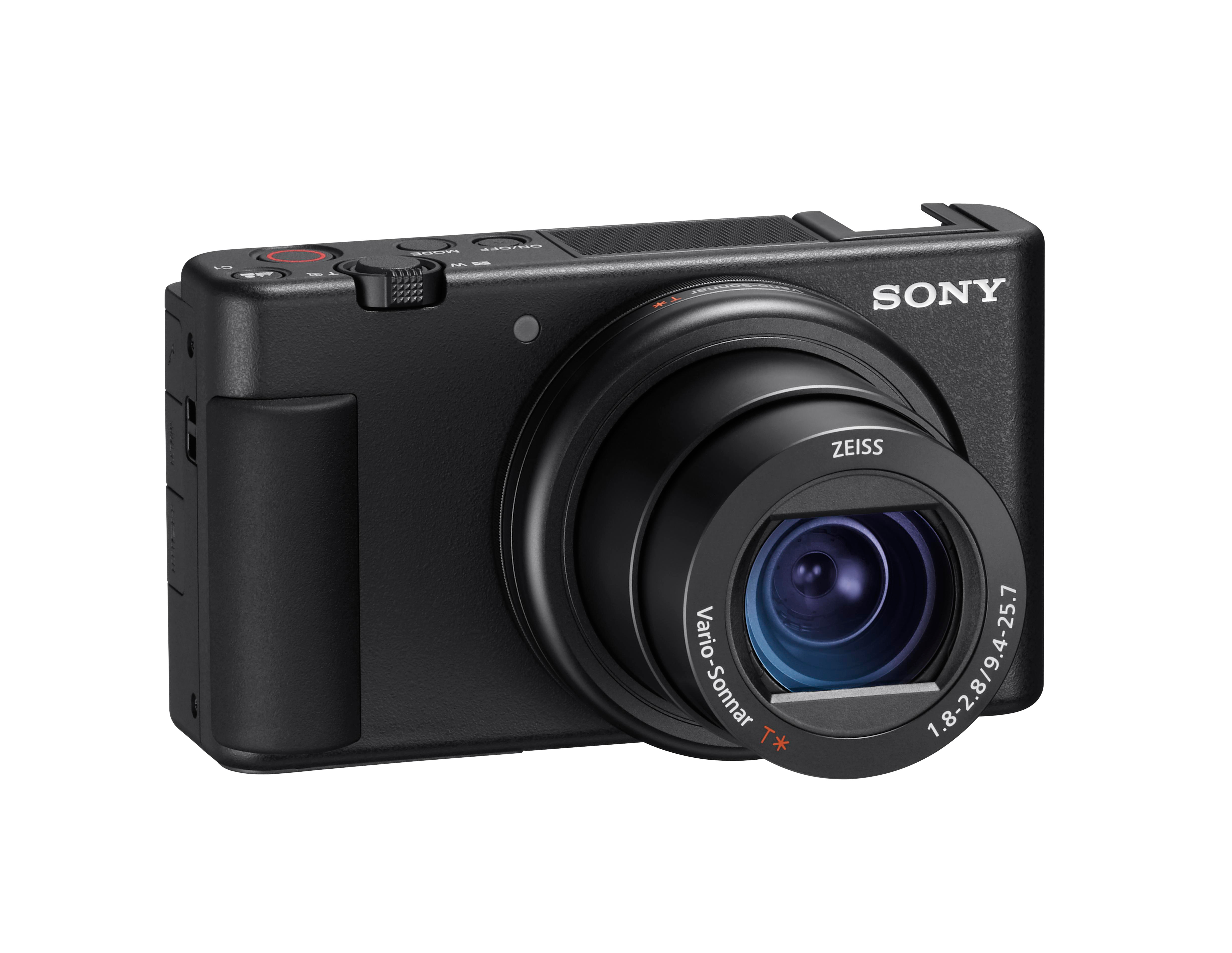 Eine schwarze Sony-Kamera mit einem Zeiss-Objektiv. Sie hat ein Vario-Sonnar-Objektiv und verschiedene Knöpfe. Der Hintergrund ist weiß.