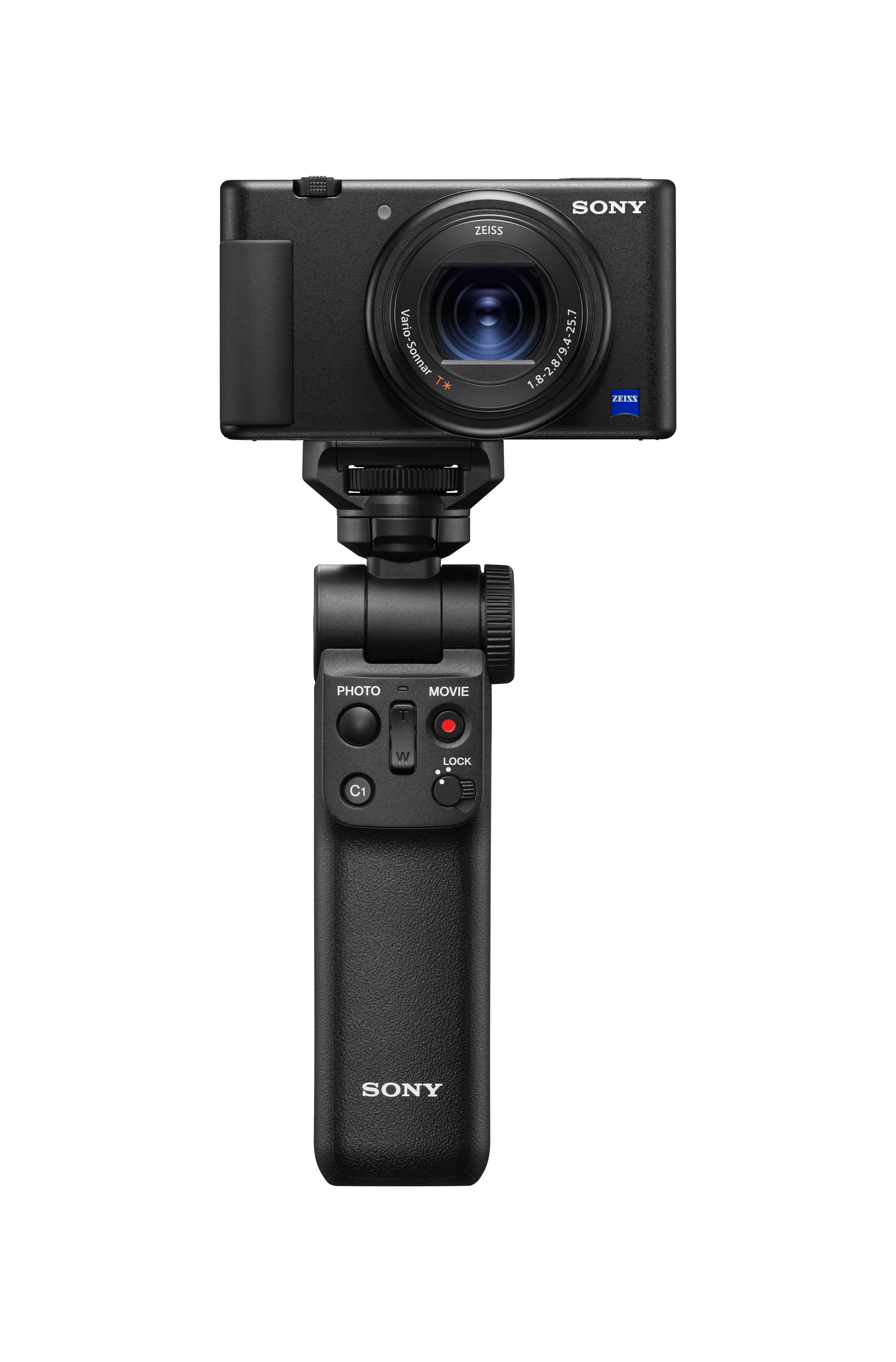 Schwarze Sony-Kamera mit Zeiss-Objektiv auf einem Griff. Tasten für Foto, Film und Bedienelemente sind sichtbar.