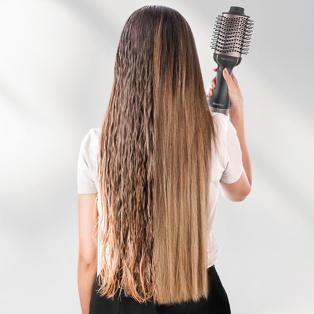 Mujer con cabello mojado sosteniendo un secador. Un lado del cabello está mojado, el otro seco y peinado. El fondo es blanco.