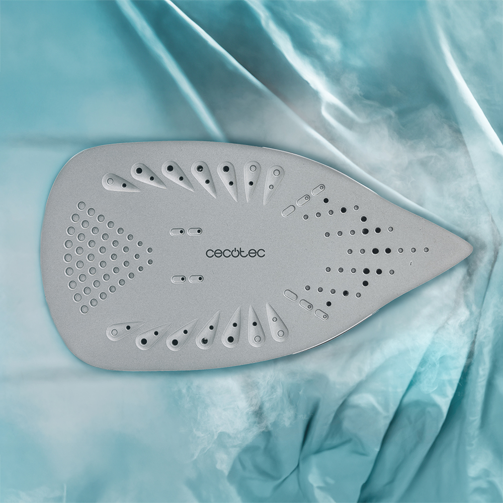 Una plancha gris con vapor sobre una tela azul. La plancha tiene forma de lágrima con la marca 'Cecotec'.