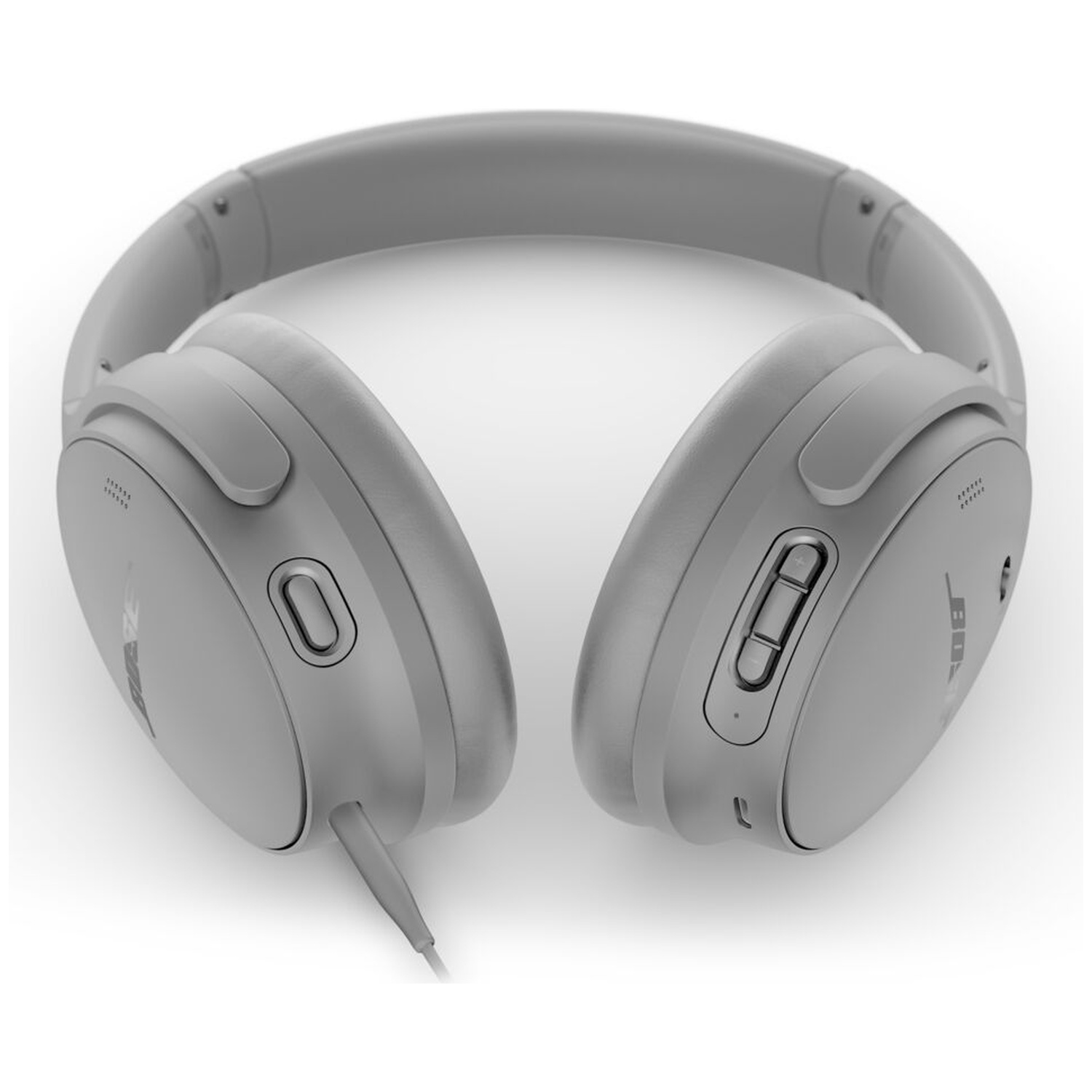 Gray headphones on a white surface. The headphones have an over-ear design with a connected cable.