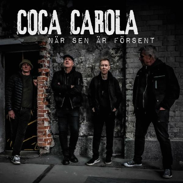 Vier Männer stehen vor einer Backsteinmauer. Der Bandname lautet „Coca Carola“. Der Text lautet „När sen är försent“.