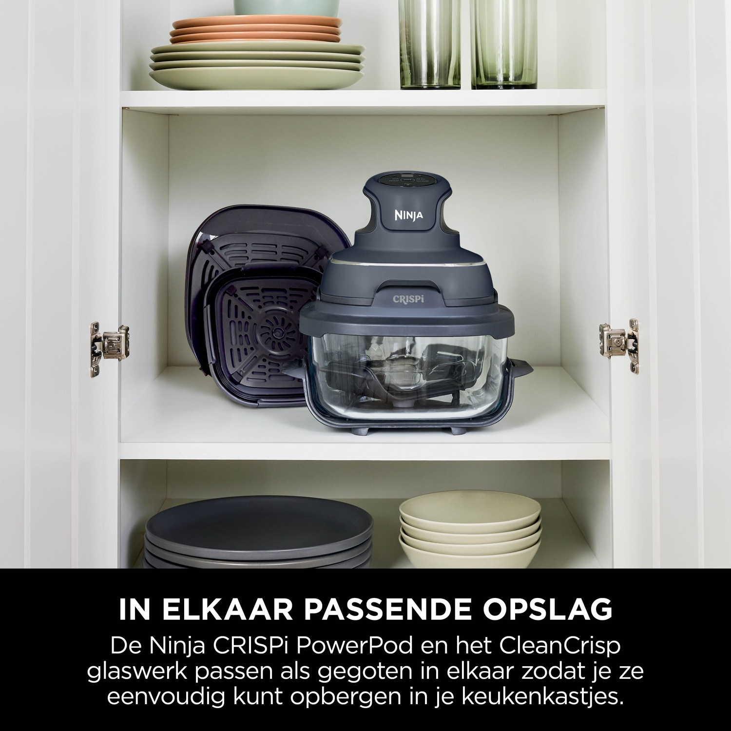 Ninja Crispi PowerPod and accessories in a white cabinet with plates and glasses.
