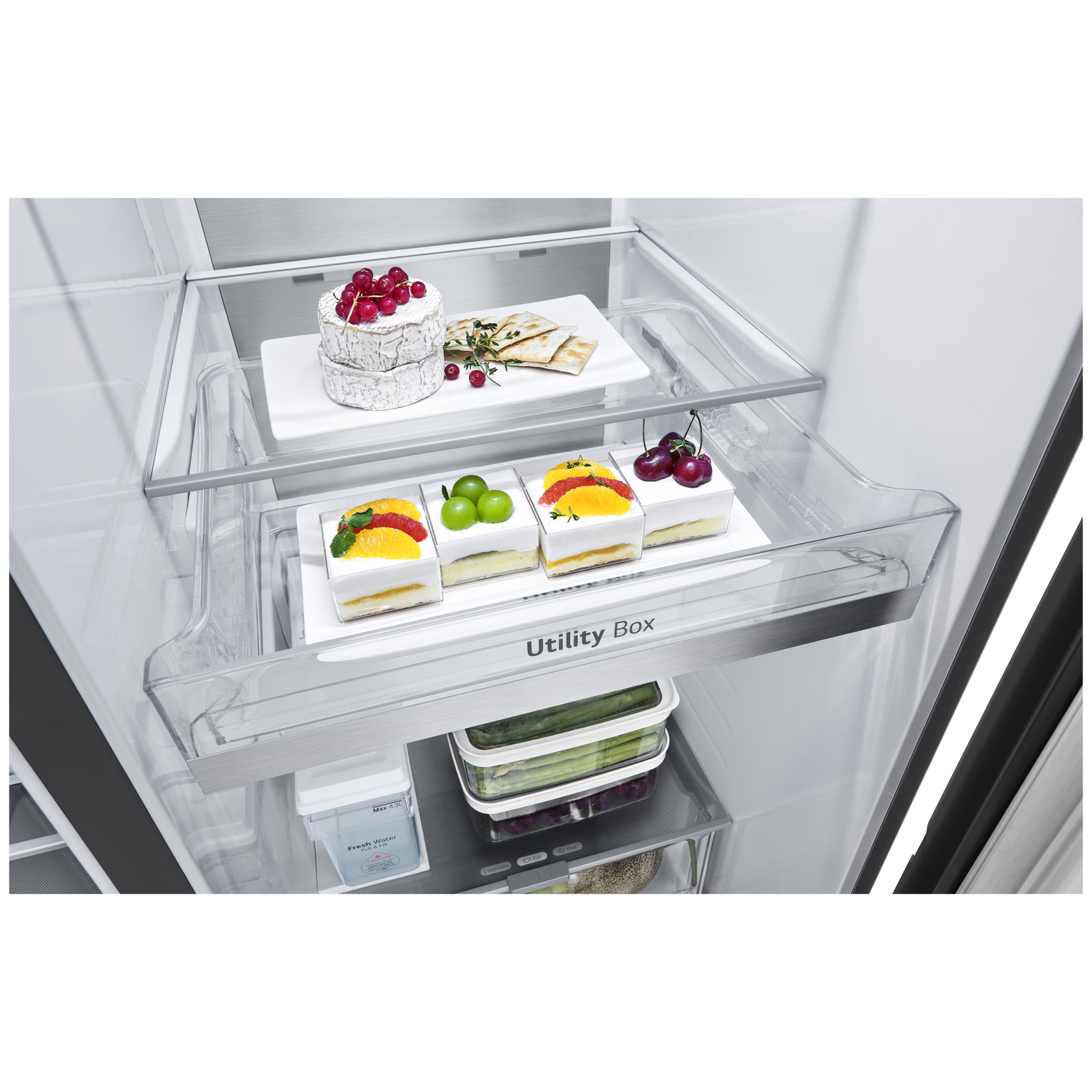 Inside a refrigerator, cakes, fruit, and snacks are arranged on shelves. A cheese wheel with berries sits on top, with a Utility Box below.