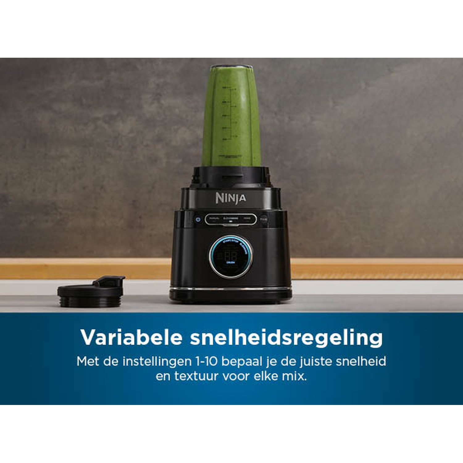 Un blender Ninja noir avec un smoothie vert. Le blender a un écran numérique et est posé sur une surface grise.