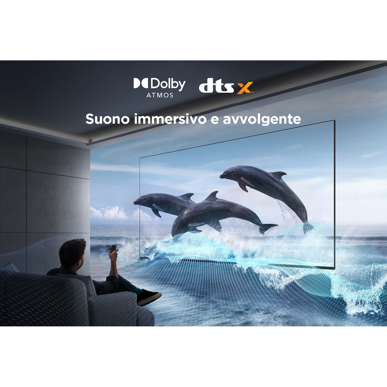 Un uomo guarda la TV con delfini che saltano dalle onde. La TV ha una cornice nera e la stanza è moderna con un divano grigio.
