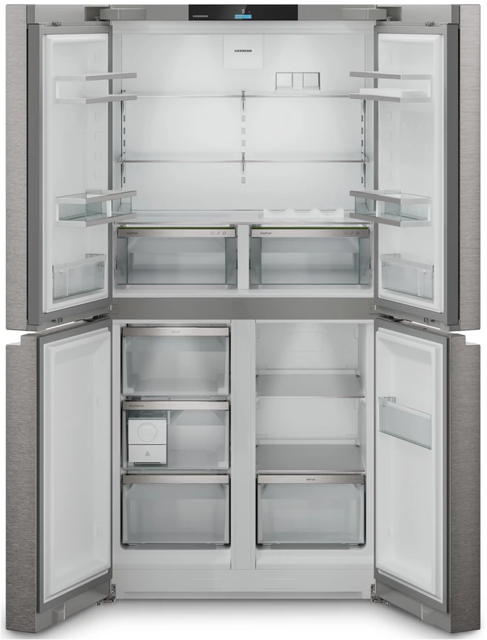 Offener Edelstahlkühlschrank mit mehreren Regalen, Schubladen und Fächern. Der Innenraum ist weiß und größtenteils leer.